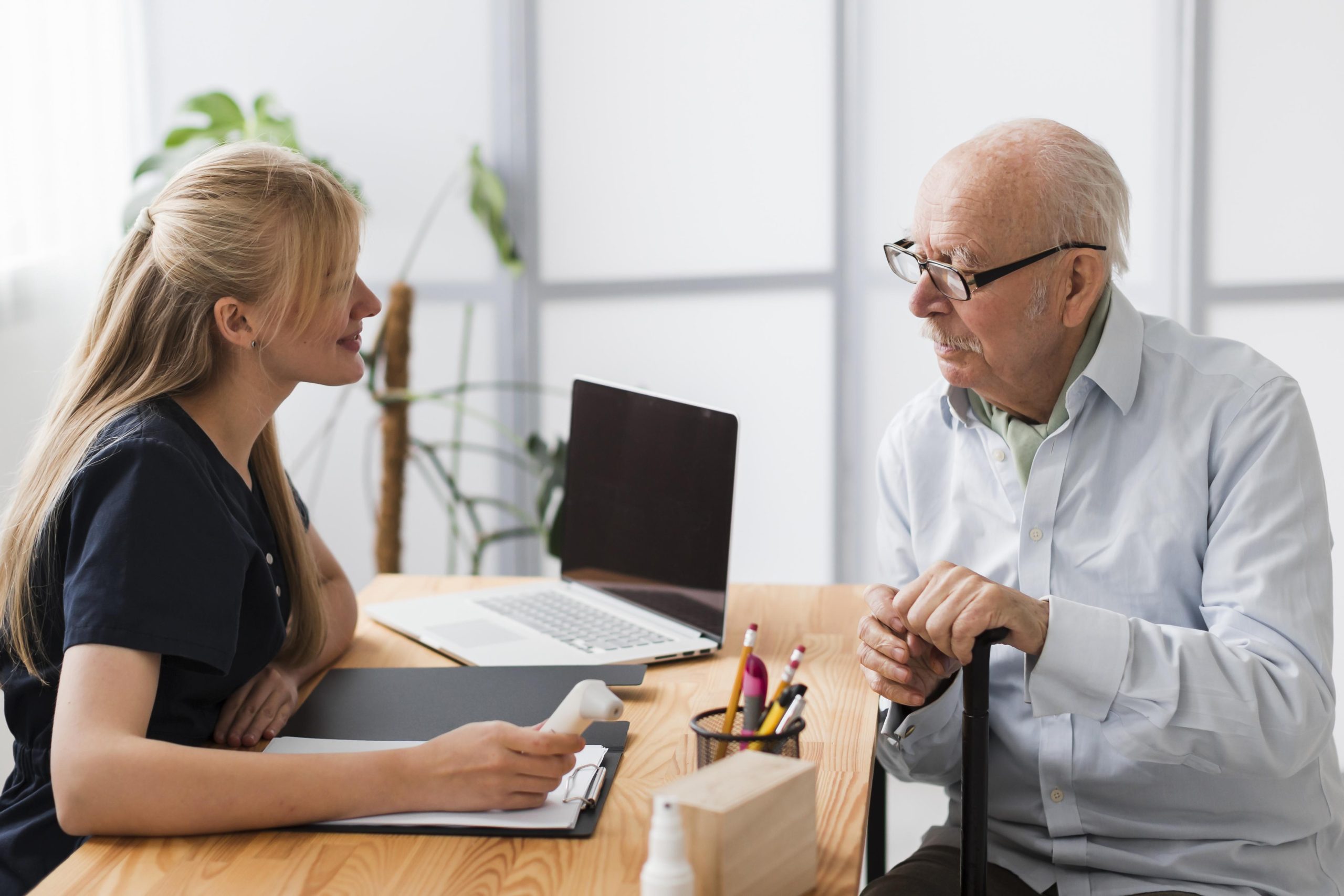 Senior man consulting with nurse about no medical exam life insurance for seniors options.